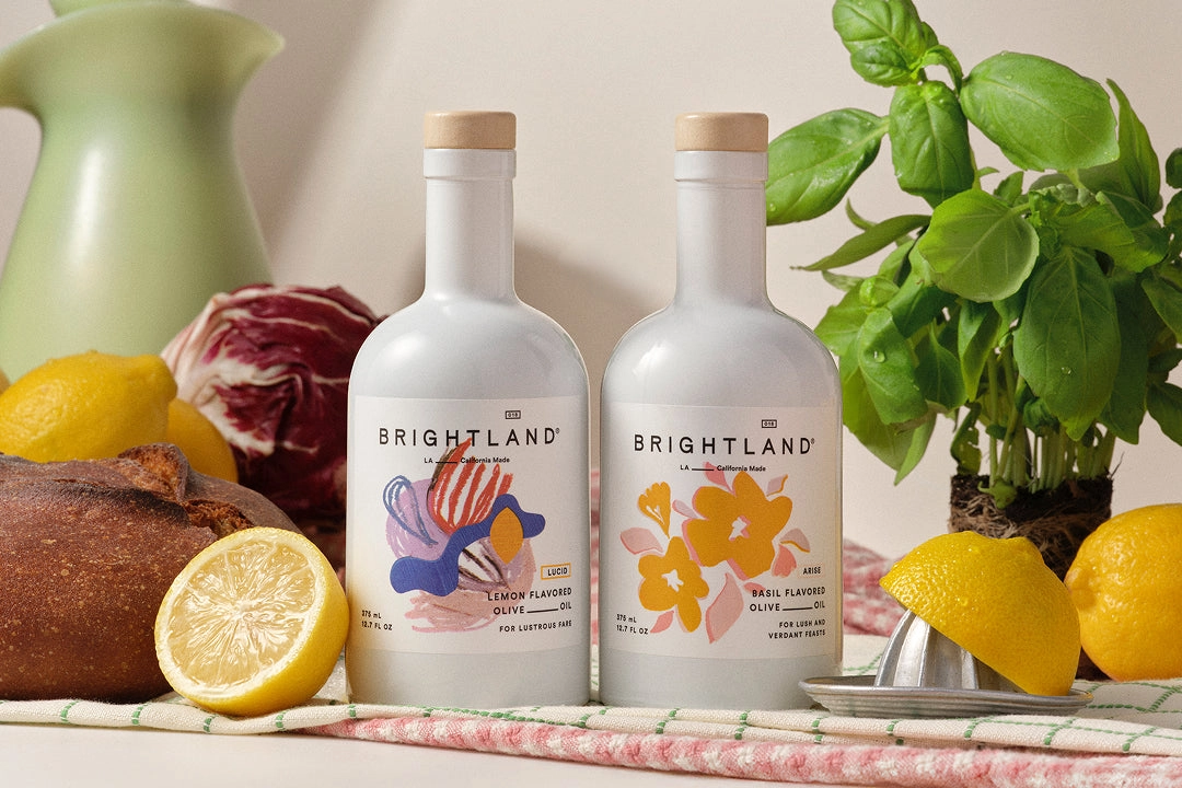 Brightland flavored olive oil bottles with lemons, basil and bread